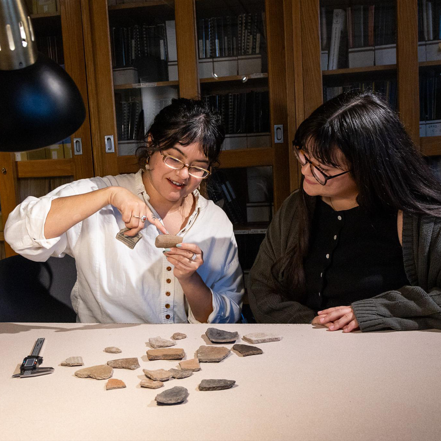 Two students examining artifacts in anthropology lab